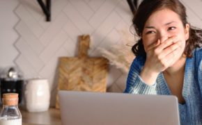 Frau hält sich vor Lachen die Hand vor den Mund