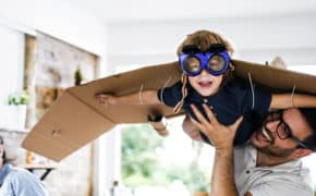Junge mit Flugzeug aus Pappe