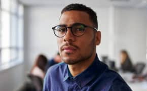 Mann mit Brille steht im Büro
