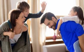 Eine Familie tobt zusammen im Wohnzimmer