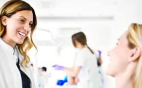 Eine Zahnärztin unterhält sich mit ihrer Patientin.