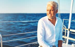 Mann sitzt auf Boot im Meer