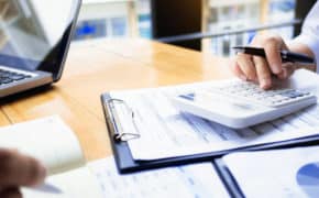 Person tippt auf Taschenrechner
