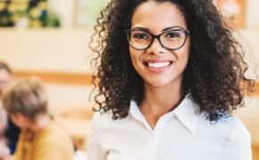 Frau mit Brille lächelt.