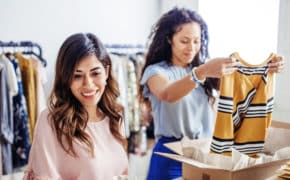 Zwei Frauen verpacken Klamotten.