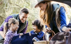 Eine Familie packt Gepäck in ihr Auto ein