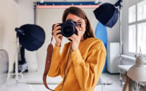 Frau in ihrem Fotoatelier mit Kamera.
