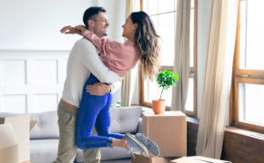 Mann und Frau umarmen sich in neuer Wohnung