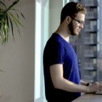 Mann vor Fenster an Laptop