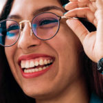 Frau setzt sich Brille auf und lacht