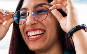 Frau setzt sich Brille auf und lacht