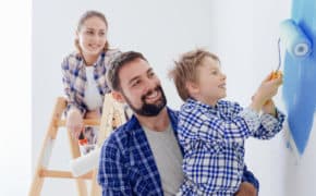 Eine junge Familie streicht zusammen ihr neues Haus.