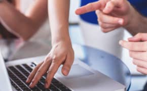 Eine Hand tippt auf Laptop-Tastatur herum.