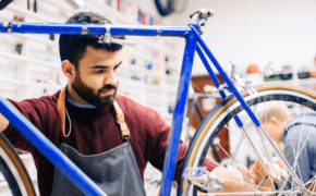 Mann repariert Fahrrad in Werkstatt