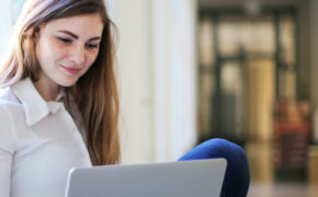 Junge Frau schaut prüfend auf ihren Laptop.