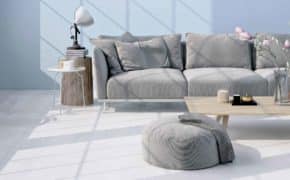 Ein Wohnzimmer mit einem grauen Sofa und einem Tisch.